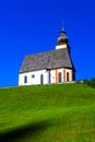 Beautiful little church in Alps. Sunny day, green grass on the h Royalty Free Stock Photo