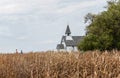 Beautiful little country church sitting behind a golden barley field. Royalty Free Stock Photo