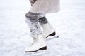 Beautiful little cute girl learn to skate on ice skating rink in park. Fall down and have fun. Stylish look, warm woolen coat, Royalty Free Stock Photo