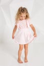 Beautiful little fashion model on white studio background. Portrait of cute girl posing in studio Royalty Free Stock Photo