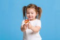 Beautiful little female child holding huge lollipop spiral candy smiling happy isolated on blue background. Royalty Free Stock Photo