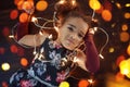 Beautiful little gir lying on the floor with garlands of lights Royalty Free Stock Photo