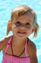 Beautiful little girl with blue eyes against the background of the pool.
