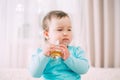 Beautiful little girl in a blue jacket with perfume in her hands Royalty Free Stock Photo