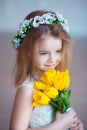 Beautiful little girl with a bouquet of tulips. Spring and summer portrait of cute child holding flowers. Royalty Free Stock Photo