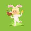 Beautiful little girl with bunny ears and rabbit costume running with basket full of painted eggs, kid having fun on Royalty Free Stock Photo