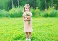 Beautiful little girl child with bouquet chamomiles flowers in summer
