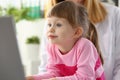 Beautiful little girl child carefully looks at monitor screen