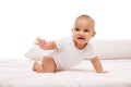 Beautiful little girl, child n white clothes lying, playing on bed, looking against white background. Stages of baby Royalty Free Stock Photo