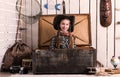 Beautiful little girl in cowboy hat sitting in wooden chest Royalty Free Stock Photo