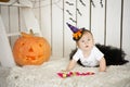 Beautiful little girl with Down syndrome sitting near a pumpkin on Halloween dressed as a skeleton Royalty Free Stock Photo