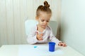 Beautiful little girl draws with finger paints on a white sheet of paper. Royalty Free Stock Photo