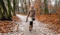 Beautiful sweet little girl dressed in a sheepskin coat and boots sitting on the trunk and in the background Royalty Free Stock Photo