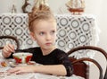 Beautiful little girl drinking tea at the table. Royalty Free Stock Photo