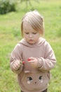 Beautiful little girl eating raspberry in the garden outdoors in summer Royalty Free Stock Photo