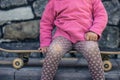 A beautiful little girl fell on skateboarding, a bruised knee in Royalty Free Stock Photo