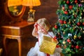 Beautiful little girl in a festive dress opens a gift Royalty Free Stock Photo