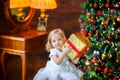 Beautiful little girl in a festive dress opens a gift Royalty Free Stock Photo