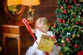 Little girl in a festive dress opens a gift Royalty Free Stock Photo