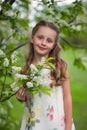 Beautiful little girl in the flowered garden with long hair Royalty Free Stock Photo