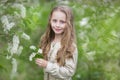 Beautiful little girl in the flowered garden with long hair Royalty Free Stock Photo