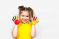 Beautiful little girl with hands in paint smiles in a yellow T-shirt. Children`s creativity. Royalty Free Stock Photo