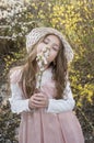 Beautiful little girl with hat in nature smells flowers Royalty Free Stock Photo