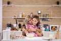 Beautiful little girl helping her mother prepare some cookies at home Royalty Free Stock Photo
