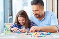 Beautiful little girl with her father playing with colored set for creativity