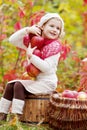 Beautiful little girl holding apples in the autumn garden. . Little girl playing in apple tree orchard. Toddler eating fruits at Royalty Free Stock Photo