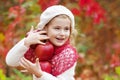 Beautiful little girl holding apples in the autumn garden. . Little girl playing in apple tree orchard. Toddler eating fruits at Royalty Free Stock Photo