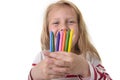 Beautiful little girl holding multicolor crayons set in art school children education concept Royalty Free Stock Photo