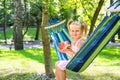 Beautiful little girl holding a watermelon and sitting on a hammock Royalty Free Stock Photo