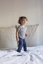 beautiful little girl jumping on bed and smiling. Fun, home, indoors. Lifestyle Royalty Free Stock Photo