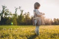 Beautiful little girl kid playing with dandelion on meadow outdoor on sunset light. Pretty cute child wearing dress enjoy and Royalty Free Stock Photo