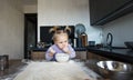 a beautiful little girl is learning to cook in the kitchen. The child spills flour on the kitchen table Royalty Free Stock Photo