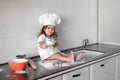 Beautiful little girl learns to cook a meal in the kitchen Royalty Free Stock Photo