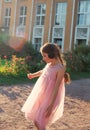 Beautiful little girl listen to music in sunny spring park. Happy cute kid having fun outdoors at sunset. Soft focused