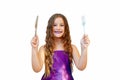 Beautiful little girl with long hair in evening dress, portrait emotionally posing with a knife and fork, isolated