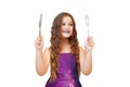 Beautiful little girl with long hair in evening dress, portrait emotionally posing with a knife and fork, isolated
