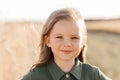 Beautiful little girl with long hair walking through a wheat field on a sunny day. Outdoors portrait. Kids relaxing Royalty Free Stock Photo