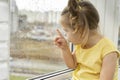 Beautiful little girl looks out the window at the rain Royalty Free Stock Photo