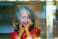 Beautiful little girl looks in the window of a shop in OIA, and makes funny faces Royalty Free Stock Photo