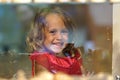 Beautiful little girl looks in the window of a shop in OIA, and makes funny faces Royalty Free Stock Photo