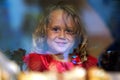 Beautiful little girl looks in the window of a shop in OIA, and makes funny faces Royalty Free Stock Photo