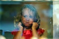 Beautiful little girl looks in the window of a shop in OIA, and makes funny faces Royalty Free Stock Photo