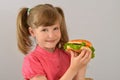 Beautiful little girl loves hamburger fastfood, convenience foods