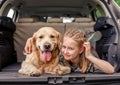 Preteen girl with golden retriever dog in the car Royalty Free Stock Photo