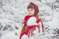 Beautiful little girl in old Russian clothes in a winter forest Royalty Free Stock Photo