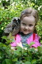 beautiful little girl with an owl on her shoulder